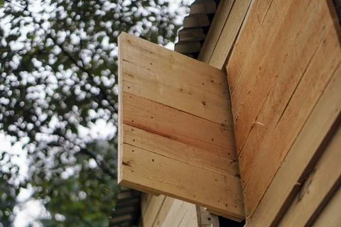 Simple wooden shutter window opened on a plank wall cabin house in the forest Stock Photos