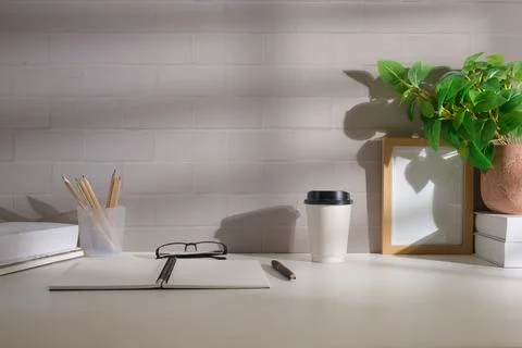 Simple workplace with notepad, eyeglasses, coffee cup, picture frame and po.. Foto stock