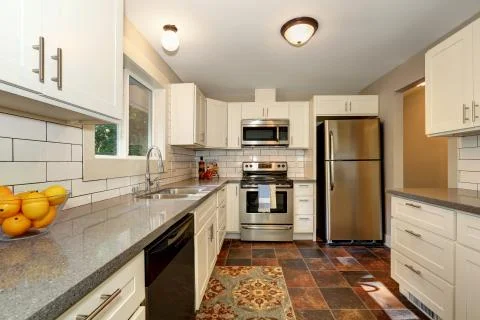 Simple yet practical kitchen interior with white modern cabinets, grey granit Stock Photos
