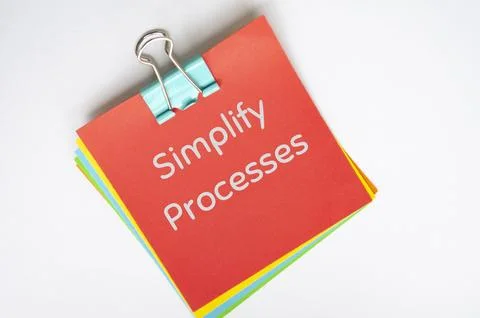 Simplify processes text on red notepad on white background Stock Photos