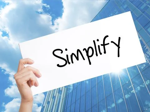 Simplify Sign on white paper. Man Hand Holding Paper with text. Isolated on S Stock Photos