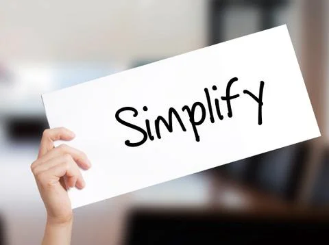 Simplify Sign on white paper. Man Hand Holding Paper with text. Isolated on O Stock Photos