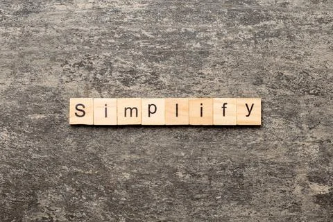 Simplify word written on wood block. simplify text on table, concept Stock Photos