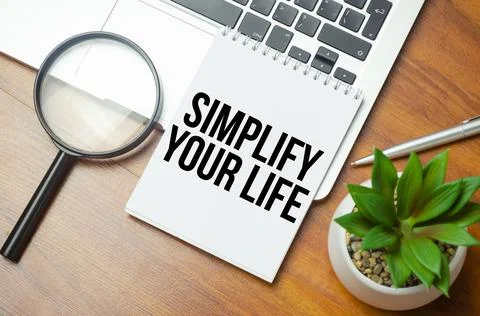 Simplify Your Life writing text post it paper in office on laptop computer ke Stock Photos