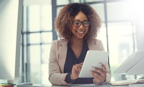 Simplifying business tasks with smart tech. a young businesswoman using a Stock Photos