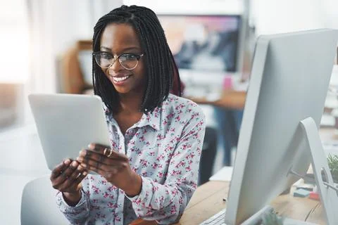 Simplifying her workflow with smart apps. a young woman using a digital tablet Stock Photos