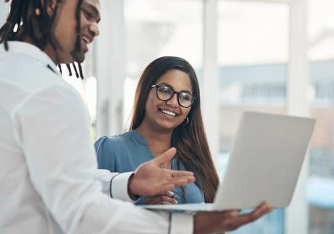 Simplifying their tasks to get ahead. two businesspeople using a laptop together Stock Photos
