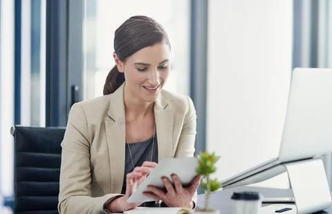 Simplifying work tasks with smart technology. a professional businesswoman using Stock Photos