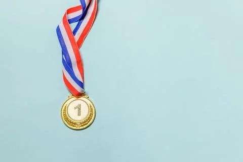 Simply flat lay design winner or champion gold trophy medal isolated on blu.. Stock Photos