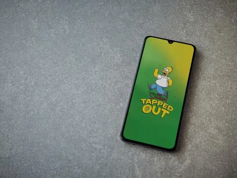 The Simpsons Tapped Out app launch screen on smartphone on ceramic stone ba.. Stock Photos