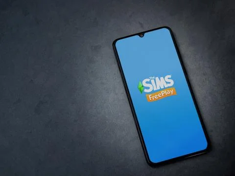 The Sims FreePlay app launch screen on smartphone on dark marble stone back.. Stock Photos