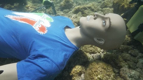 SImulation underwater divers turn dummy upside down in close'up, Ustica. Med sea Stock Footage 124388428