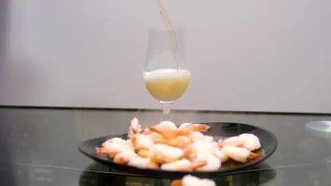 Simultaneously pour hot boiled shrimps into a plate and pour a glass of beer 스톡 동영상 302111702