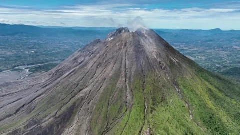 Sinabung ash grey flanks sweep into a fan of frozen lava rivers, reminding the Stock Footage 328628427