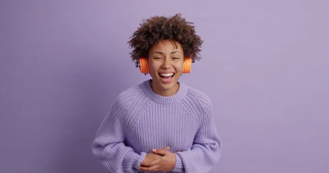 Sincere dark skinned woman cannot stop laughing holds stomach hears funny Stock Footage 144453932