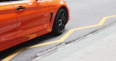 Singapore 08.10.2023: Low Angle Side View of an orange BMW M Driving Stock Footage 252888900