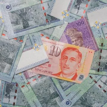 Singapore dollar on top of Malaysian Ringgit currency on background Foto stock