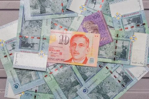 Singapore dollar on top of Malaysian Ringgit currency on background Stock Photos
