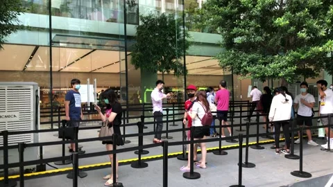 Singapore: People queue in front of an Apple Store on Orchard Road, 4K Stock Footage 134589808