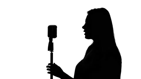 Singer approached the microphone and began to sing. Close up. Silhouette. White 動画素材 64276361