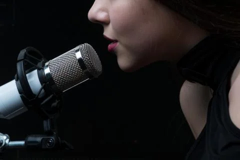 Singer in front of a microphone. Isolated on a dark background Foto stock