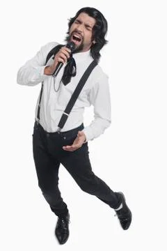 Singer holding a mike and singing Stock Photos
