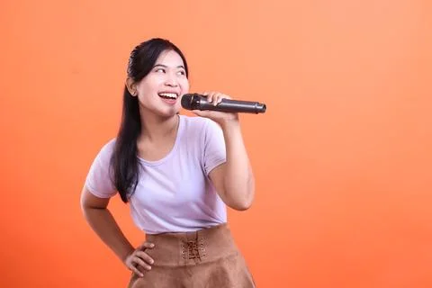 Singer with mic on orange Stock Photos