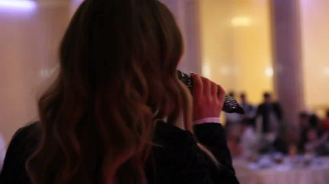 A singer with a microphone on stage at restaurant. Video stock 35596274