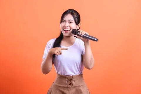 Singer Pointing Mic, Orange Backdrop Stock Photos