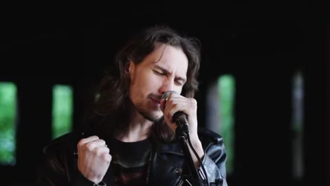 A singer sings into a microphone in an old building Stock Footage 132089917