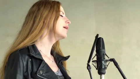 Singer sings into a microphone in a recording studio Stock Footage 73754982