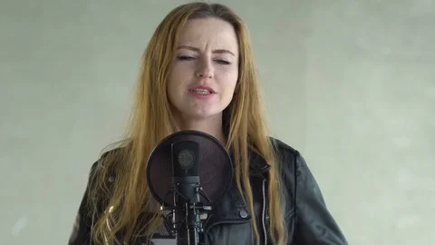 Singer sings to microphone at the studio Stock Footage 73755298