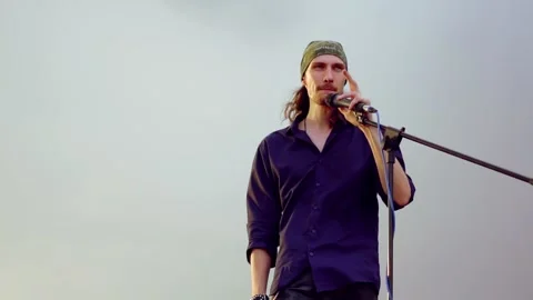 The singer sings on the street in the microphone Stock Footage 132435705