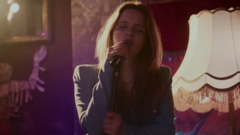 A singer on the stage holding a microphone and singing in front of an audienc Vídeo Stock 258288973
