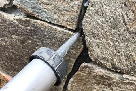 Singing gaps between the wild stone on the cladding of the found Stock Photos