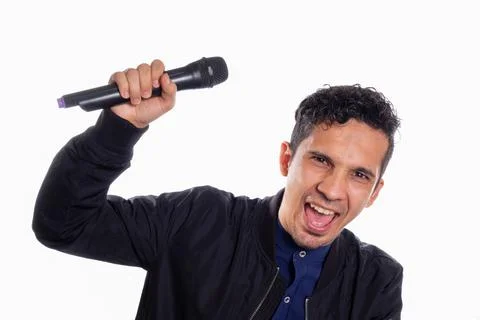 Singing man shouting and looking at the camera. White background. Young latino Foto stock