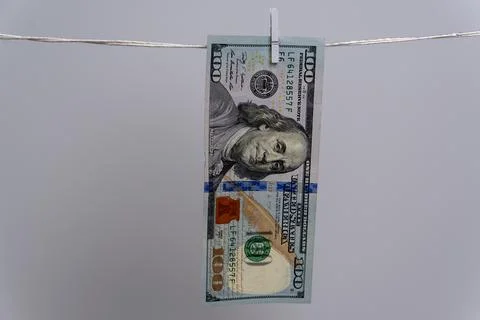 Single 100 Dollar Bill Hanging on Clothesline for Money Laundering Concept Fotos Stock