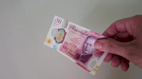 Single £50 note featuring King Charles III held against a white background Stock Footage 334231328
