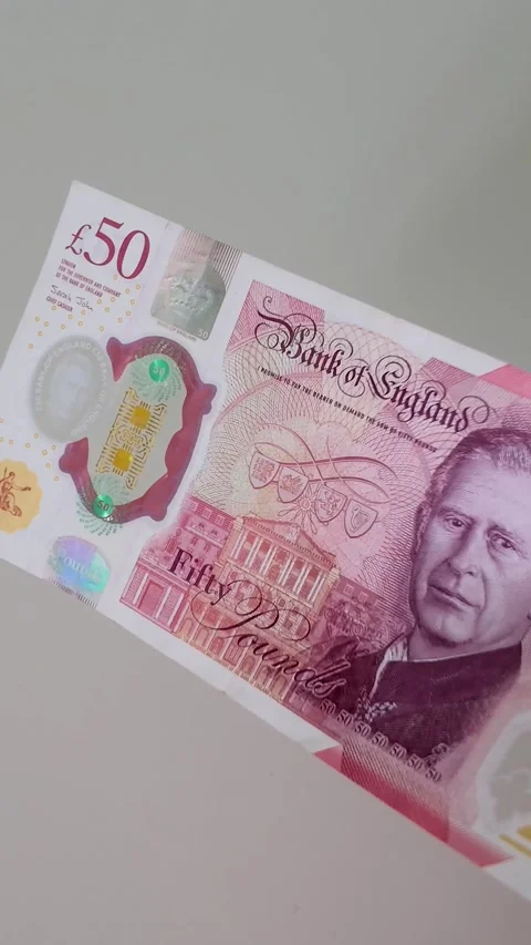Single £50 note featuring King Charles III held against a white background Stock Footage 334241567