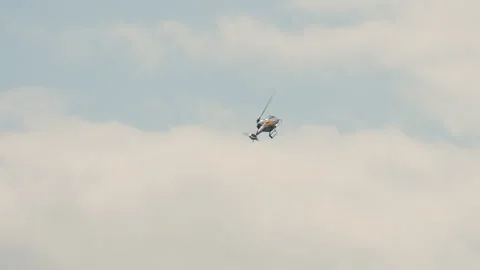 Single aerobatic helicopter banking in overcast grey sky Stock Footage 336733512
