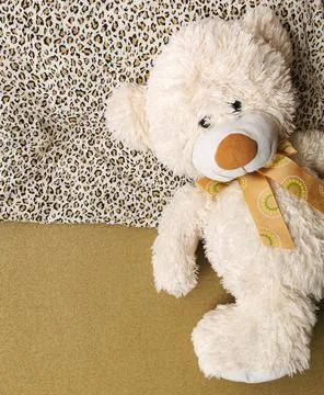 Single, alone, lonely teddy bear in bed is lying on the pillow Stock Photos