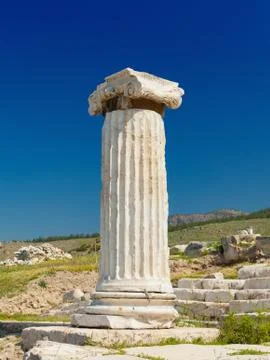 Single ancient column against clear blue sky Фото