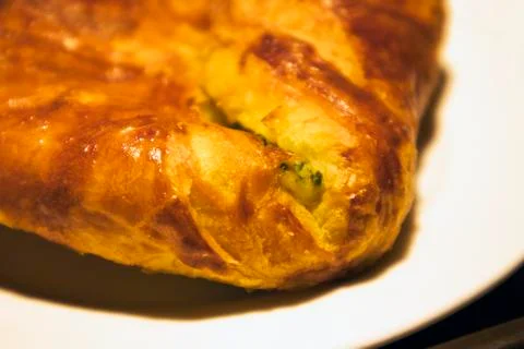 Single appetizing ruddy spinach pie on a white plate Stock Photos