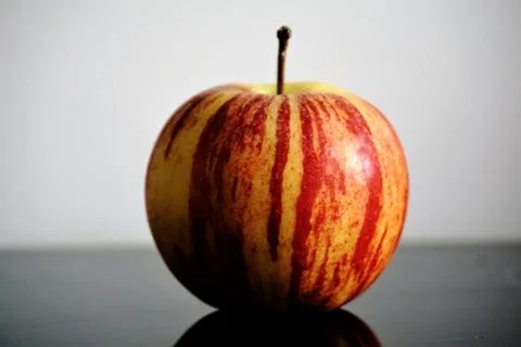 Single apple on glass table Stock Photos