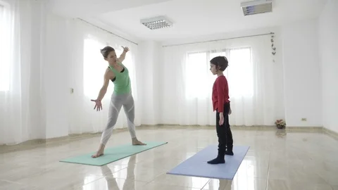 Single beautiful young mother teaching her daughter yoga pilates exercises us Stock Footage 87209627