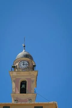 Single belltower with clock on blue sky in Camogli, Italy Stock Photos