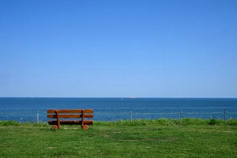 A single bench on a steep coast of the Baltic Sea Stock Photos