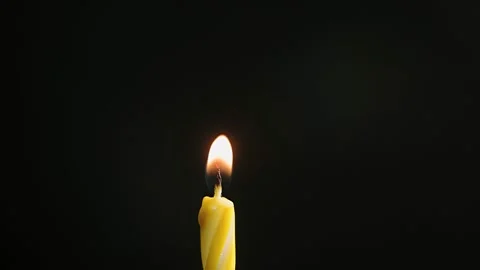 Single big yellow candle flame lights and extinguish, isolated on a black Stock Footage 172080397