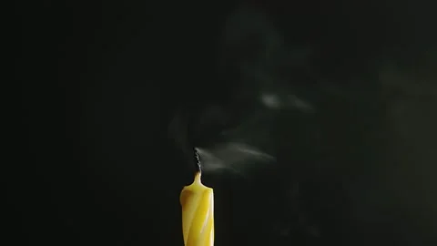Single big yellow candle flame lights and extinguish, isolated on a black Stock Footage 172080480