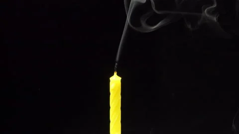 Single big yellow candle flame lights and extinguish, isolated on a black Stock Footage 222780619